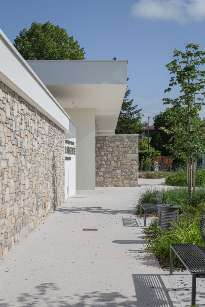 Architecture contemporaine du gymnase du groupe scolaire Largenté à Bayonne, avec parement en pierre et lignes épurées.