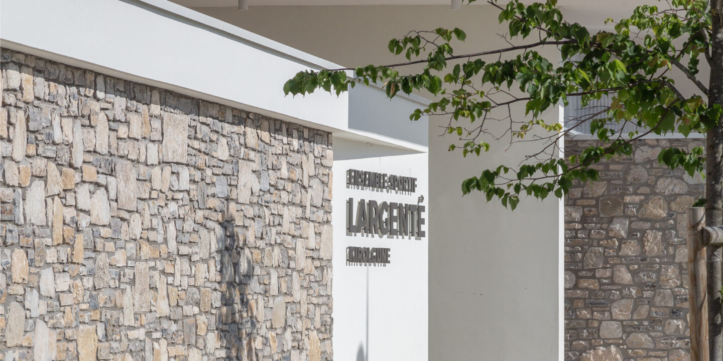 Gymnase du groupe scolaire Largenté à Bayonne, vue extérieure du bâtiment avec façade en pierre et architecture contemporaine.