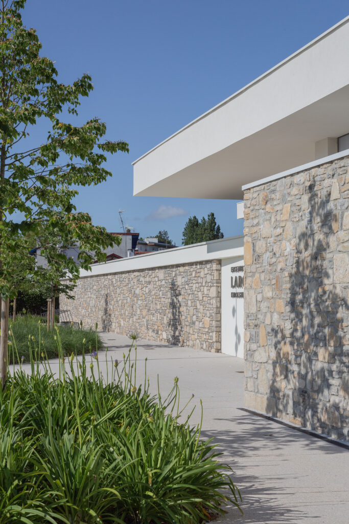 Façade principale du gymnase du groupe scolaire Largenté à Bayonne, associant pierre naturelle et volumes contemporains.