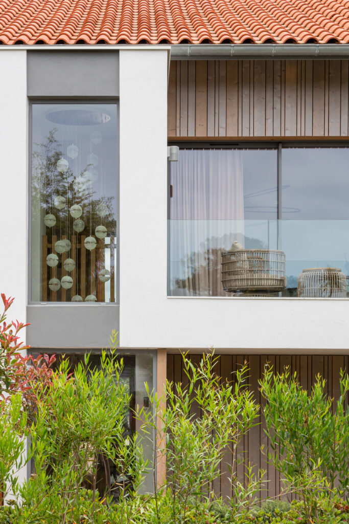 Architecture contemporaine d'une villa rénovée à Chiberta avec terrasse suspendue et garde-corps en verre.