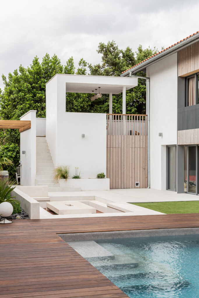 Piscine bordée d'une terrasse en bois dans le cadre de la rénovation d'une villa à Anglet.