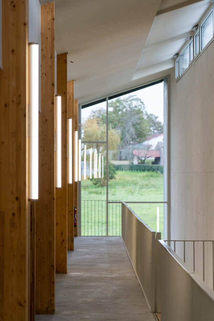 Circulation intérieure reliant bureaux, coworking et ateliers dans la pépinière agroalimentaire.