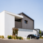 Façade contemporaine de l'atelier de menuiserie Castel à Villefranque avec bardage bois vertical et volumes géométriques.