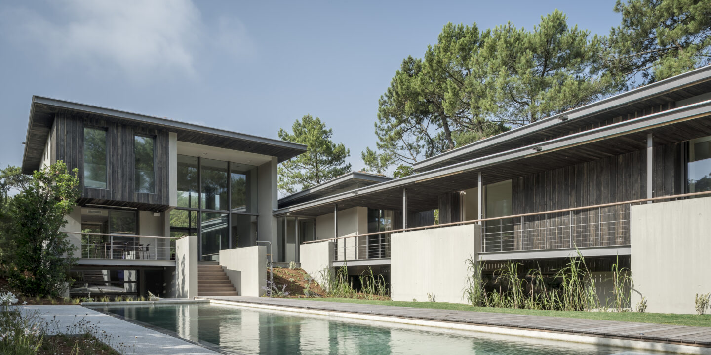 Vue principale d'une villa d'architecte contemporaine ouverte sur le jardin.