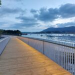 Passerelle Caneta illuminée au crépuscule, reflet doré dans l'eau calme de la baie d'Hendaye.