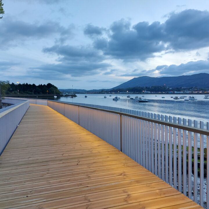 Passerelle Caneta illuminée au crépuscule, reflet doré dans l'eau calme de la baie d'Hendaye.