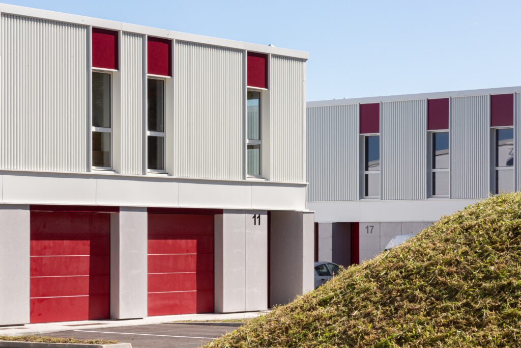 Façade sur cour du village d'artisans Etxondo, modules à ossature métallique gris clair